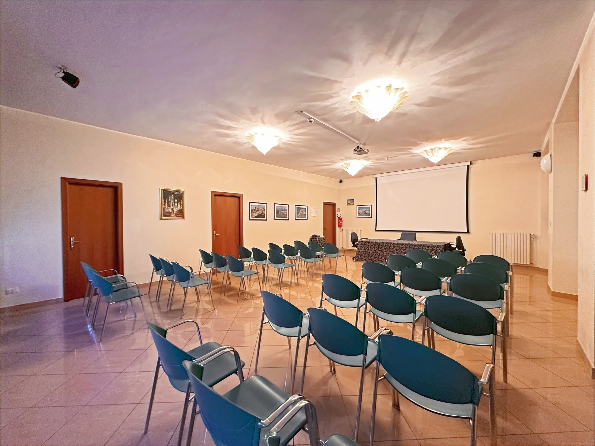 Sala allestita a platea con schermo per proiezioni, affacciata sul parco privato del Nazareth Residence
