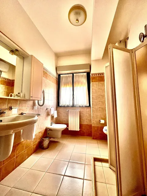 En-suite bathroom with shower, bidet and window, tiled in Viterbo terracotta tones