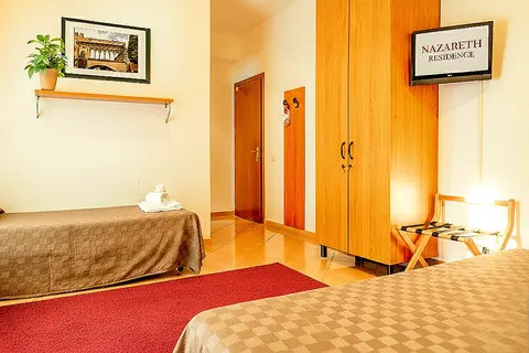 Single room with wooden wardrobe and TV at Nazareth Residence in central Viterbo