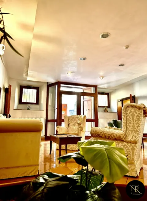 The lobby with ivory damask armchairs and glass entrance on Via San Tommaso, Viterbo