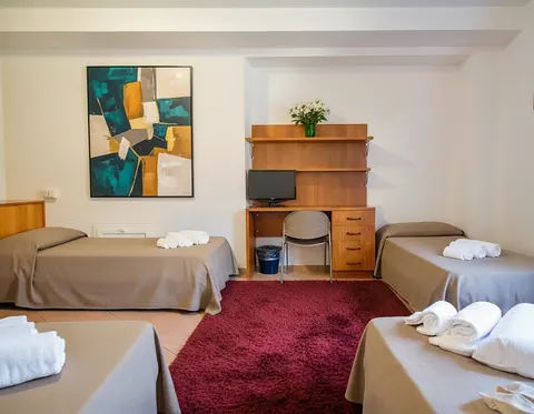 Quadruple room with four single beds and a desk, for families and groups in central Viterbo