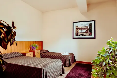 Twin room with separate beds and a print of Viterbo's Palazzo dei Papi