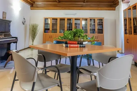 Meeting room with coffered wooden ceiling, square table and glass bookcase, for meetings in Viterbo