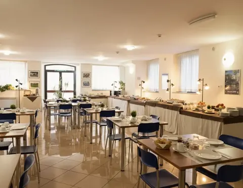 Breakfast room with laid tables, blue chairs and a buffet along the wall, Nazareth Residence Viterbo