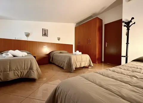 Multi-bed room with three single beds and a large wardrobe, for groups and Via Francigena pilgrims