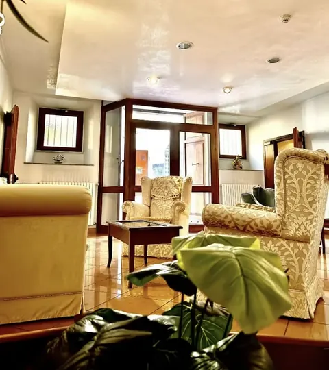 The lobby with ivory damask armchairs, wooden table and glass entrance, tourist accommodation in Viterbo